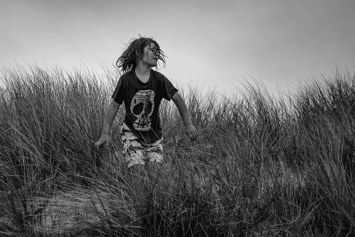 child in sand dunes with wet hair